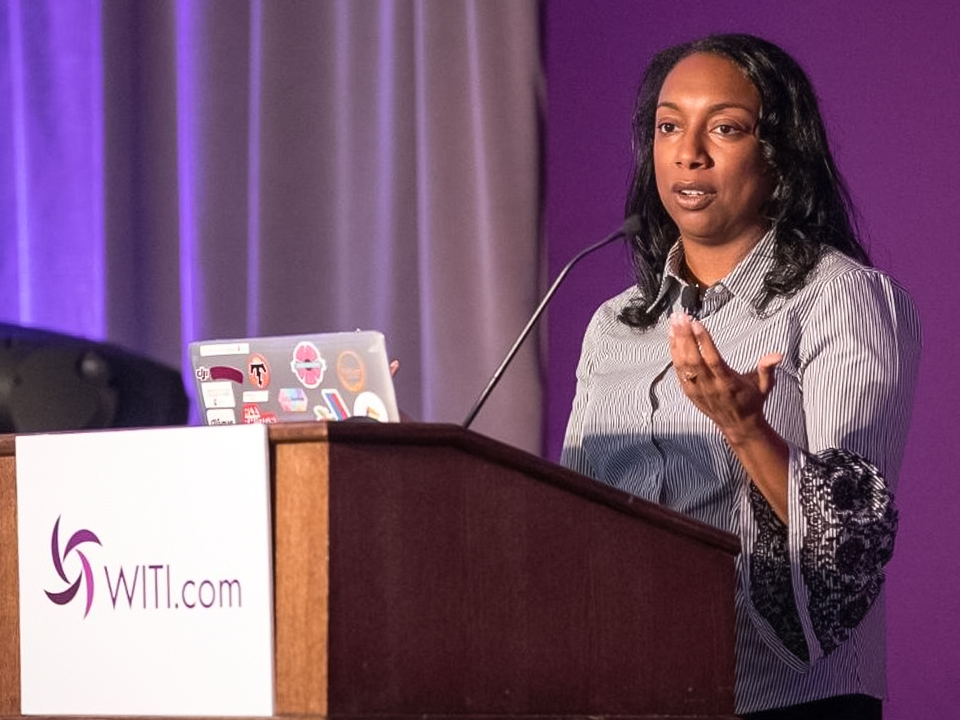 Kesha Williams speaking behind a podium at a Woman In Tech event